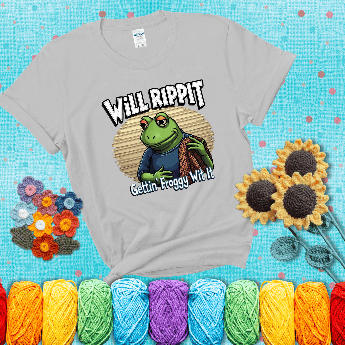 Cool frog with sunglasses, surrounded by yarn and hooks. Text reads: “Gettin’ Froggy Wit It.” A hip and humorous crochet tee for yarn lovers with rhythm, showing a light grey tee with a teal sunflower background