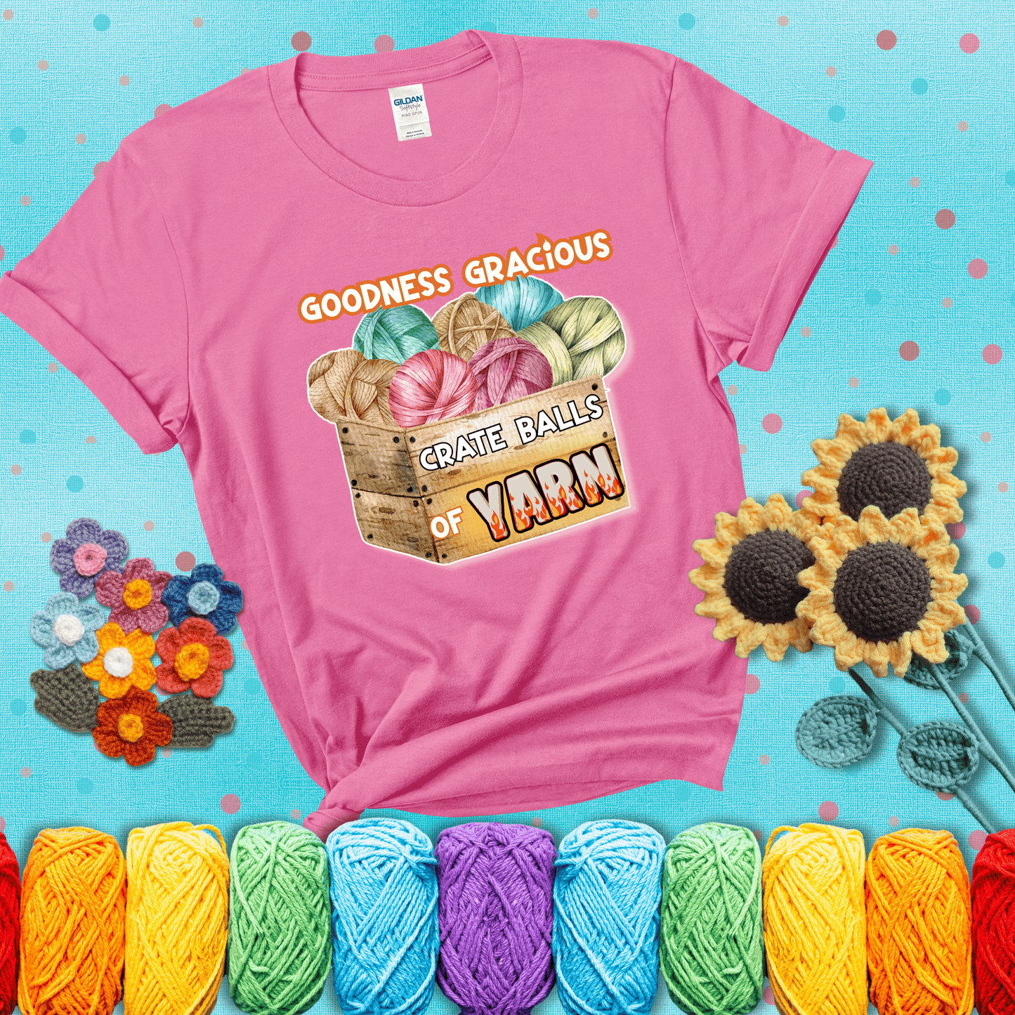 Wooden crate filled with colorful yarn balls and bold text “Goodness Gracious, Crate Balls of Yarn” with flame effects, a funny gift for crocheters showing a pink tee with a teal sunflower background