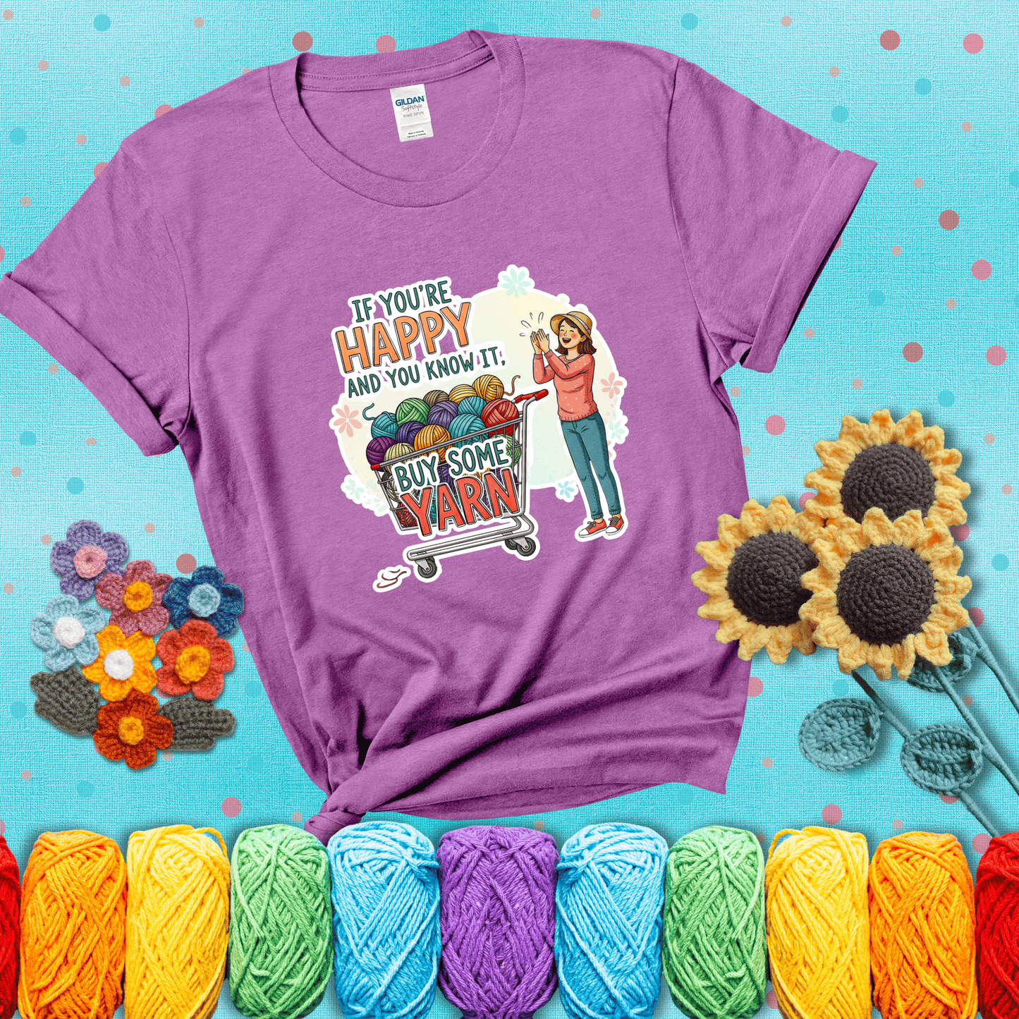 Woman clapping beside a shopping cart overflowing with colorful yarn balls, styled with cheerful pastel accents and bold playful lettering showing a light purple tee with a teal sunflower background