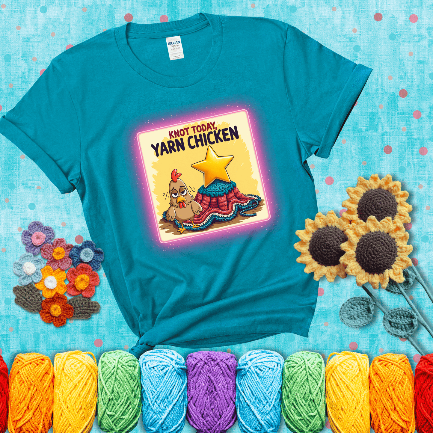 A frazzled cartoon chicken stands next to a nearly-finished project with minimal yarn left, with the phrase “Knot Today, Yarn Chicken” above, showing a blue-green tee with a teal sunflower background
