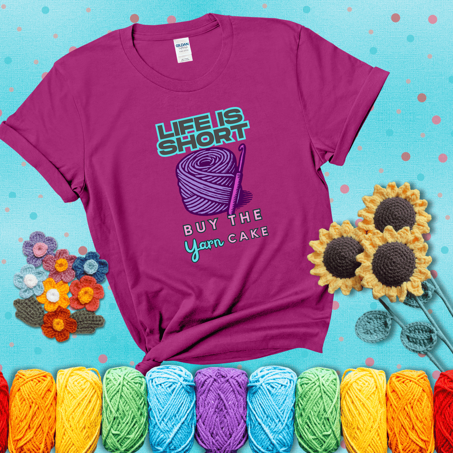 No regrets, just yarn Design reads 'Life Is Short. Buy The Yarn (Cake)' , perfect crochet gift for yarn lovers, showing a magenta tee with a teal sunflower background