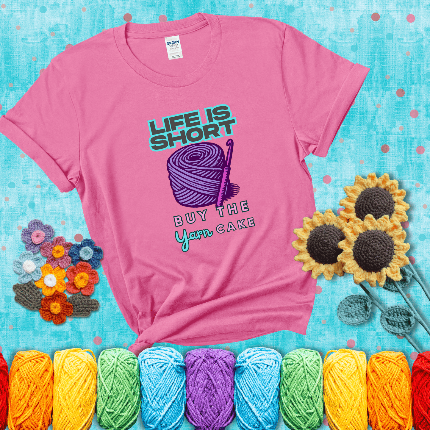No regrets, just yarn Design reads 'Life Is Short. Buy The Yarn (Cake)' , perfect crochet gift for yarn lovers, showing a pink tee with a teal sunflower background