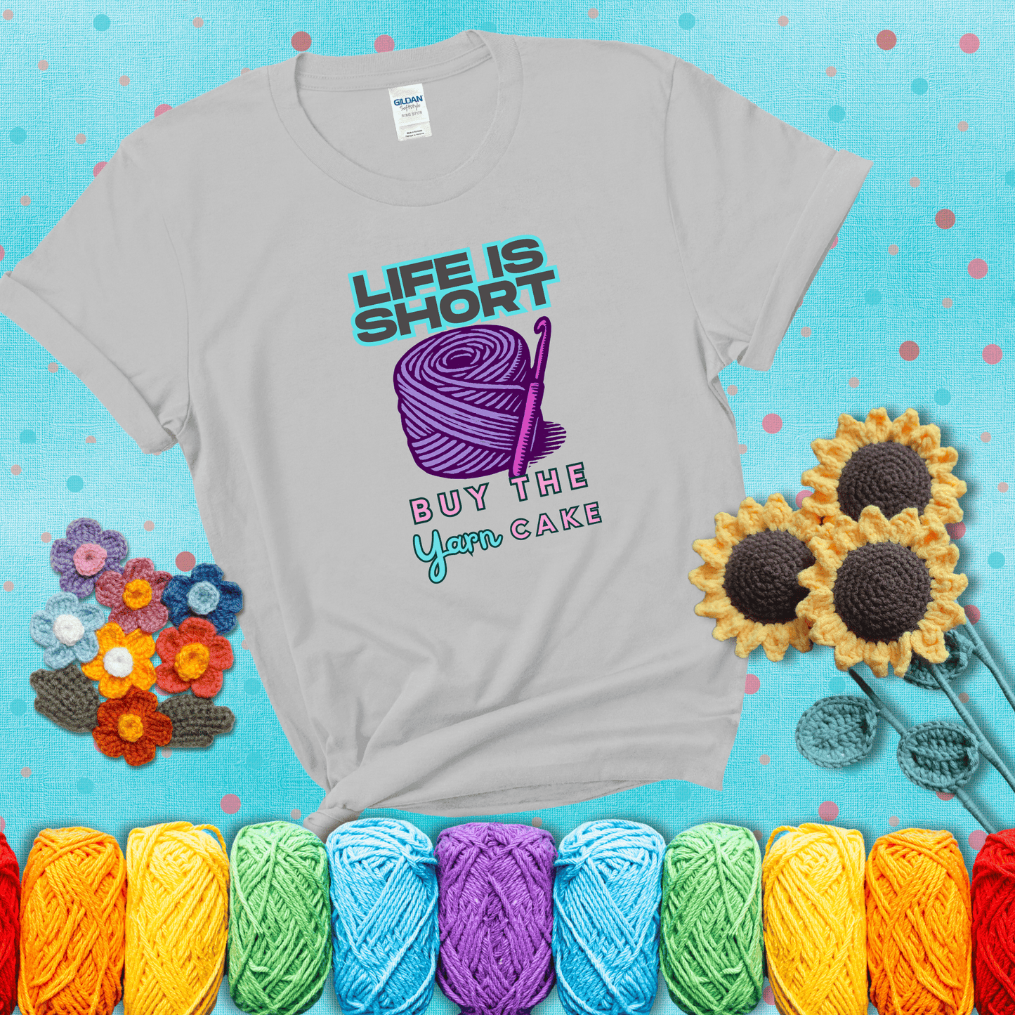 No regrets, just yarn Design reads 'Life Is Short. Buy The Yarn (Cake)' , perfect crochet gift for yarn lovers, showing a light grey tee with a teal sunflower background