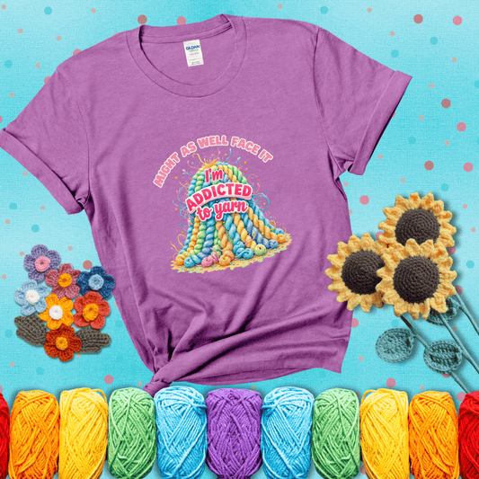Colorful mountain of pastel yarn hanks with the phrase “Might as well face it, I’m addicted to yarn” in playful pink and red lettering showing a light purple tee with a teal sunflower background