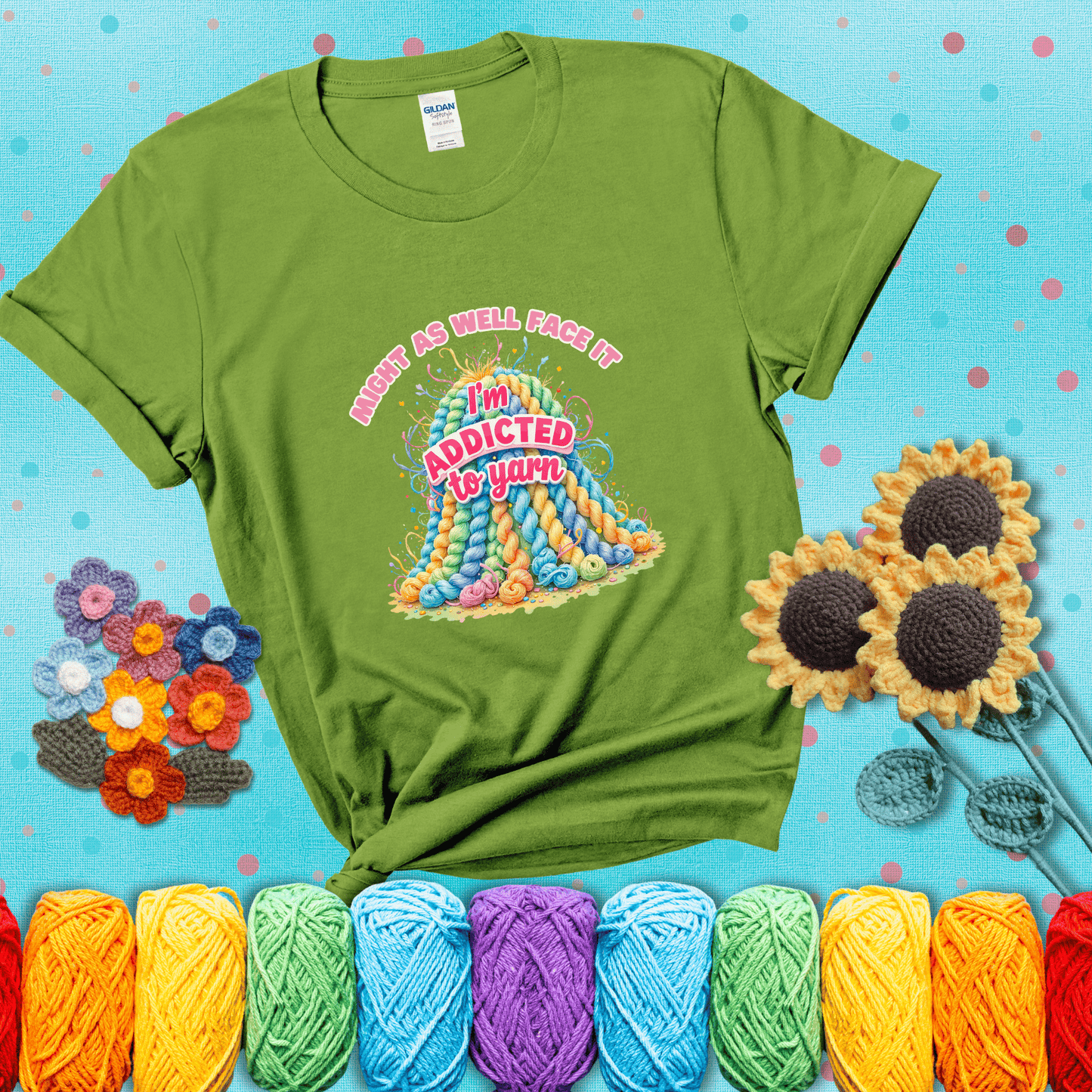 Colorful mountain of pastel yarn hanks with the phrase “Might as well face it, I’m addicted to yarn” in playful pink and red lettering showing a bright green tee with a teal sunflower background