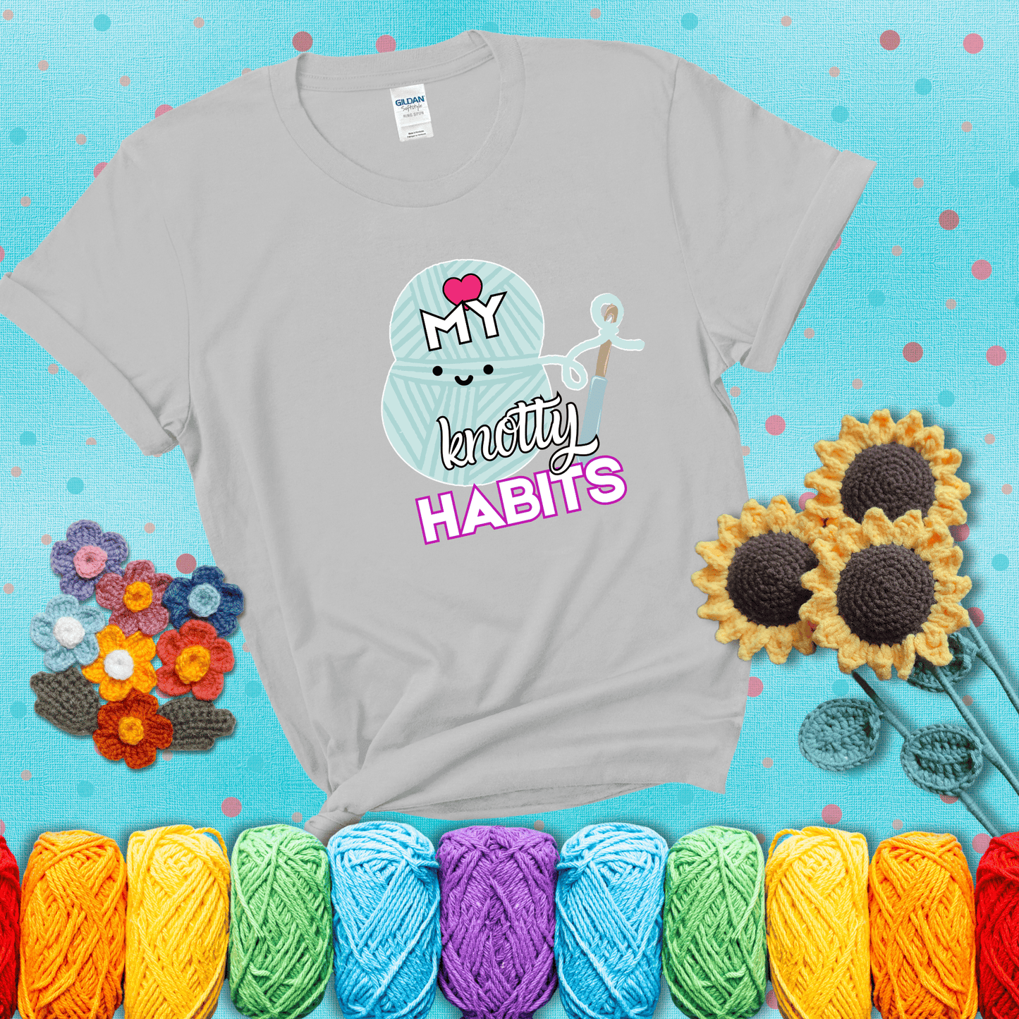 Smiling yarn ball and hook with text “Love My Knotty Habits” - cute crochet shirt with playful design for makers, showing a light grey tee with a teal sunflower background