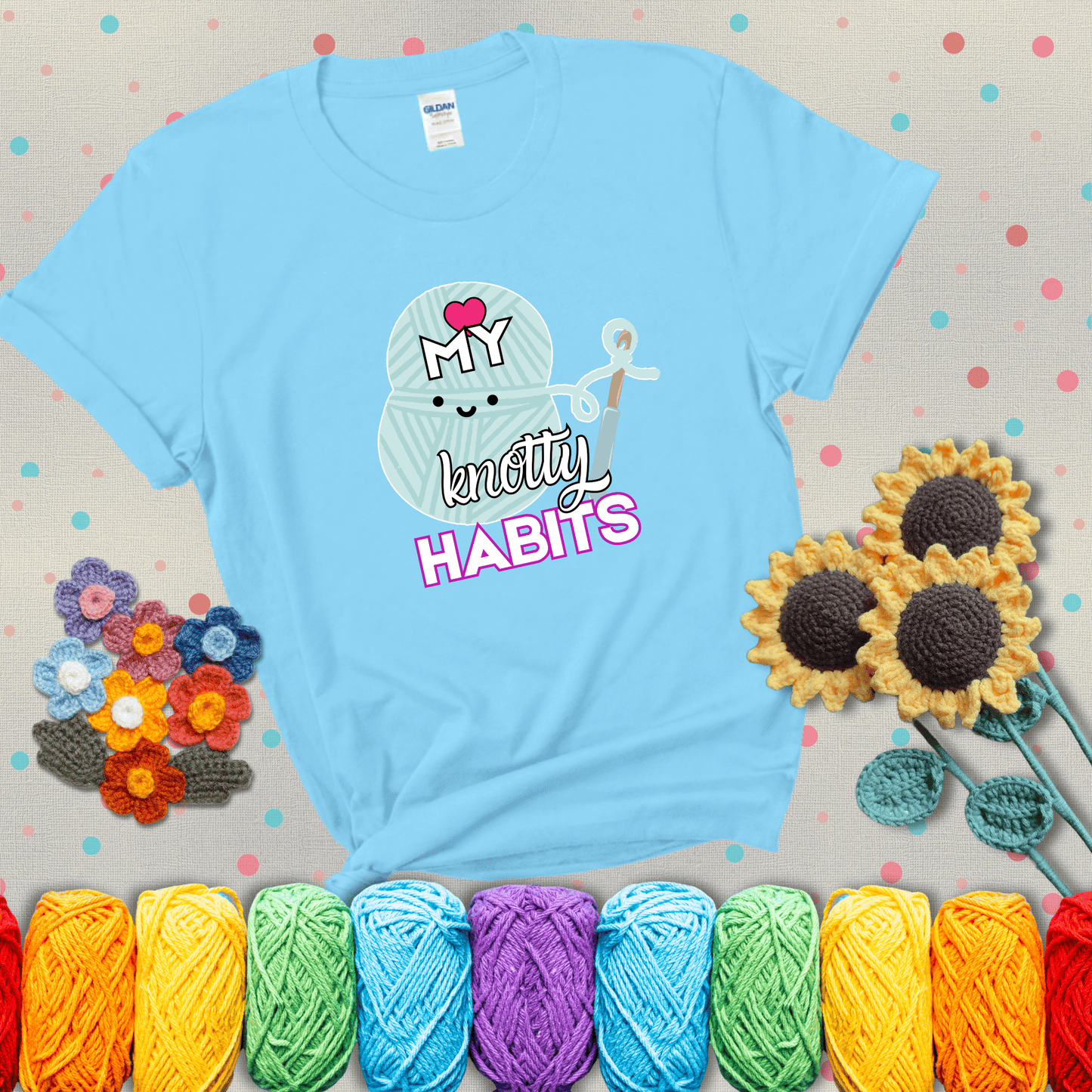 Smiling yarn ball and hook with text “Love My Knotty Habits” - cute crochet shirt with playful design for makers, showing a light blue tee with grey sunflower background