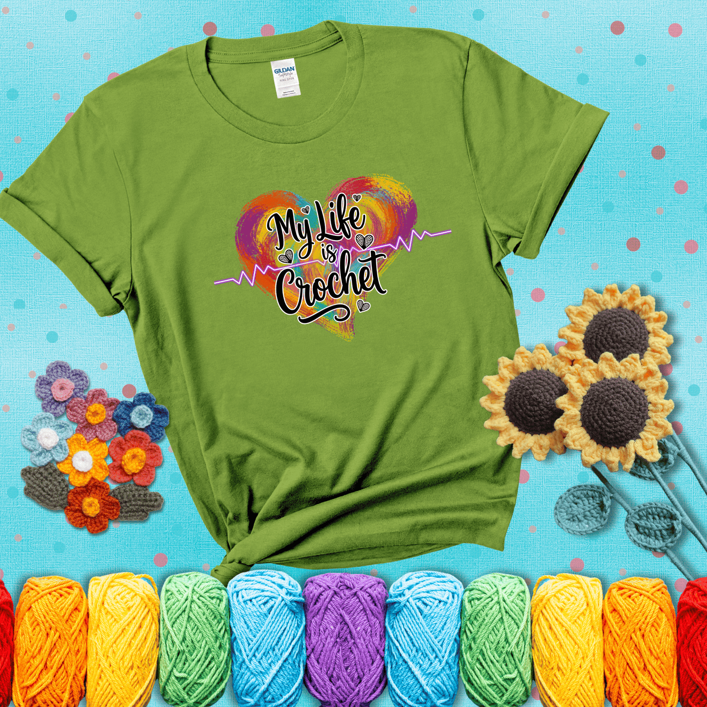 Colorful heart with an EKG line and text: “My Life is Crochet” in bold script showing a bright green tee with a teal sunflower background