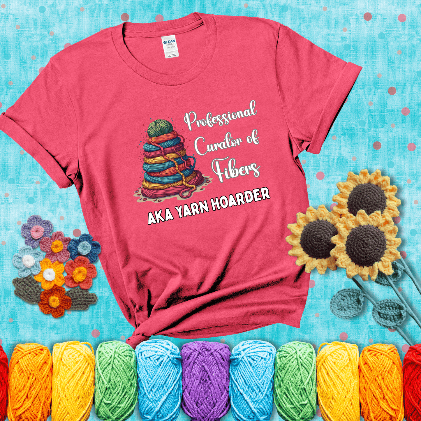 Pyramid of rainbow yarn topped with green ball; text reads “Professional Curator of Fibers AKA Yarn Hoarder,” a playful shirt for serious stashers showing a light red tee with a teal sunflower background