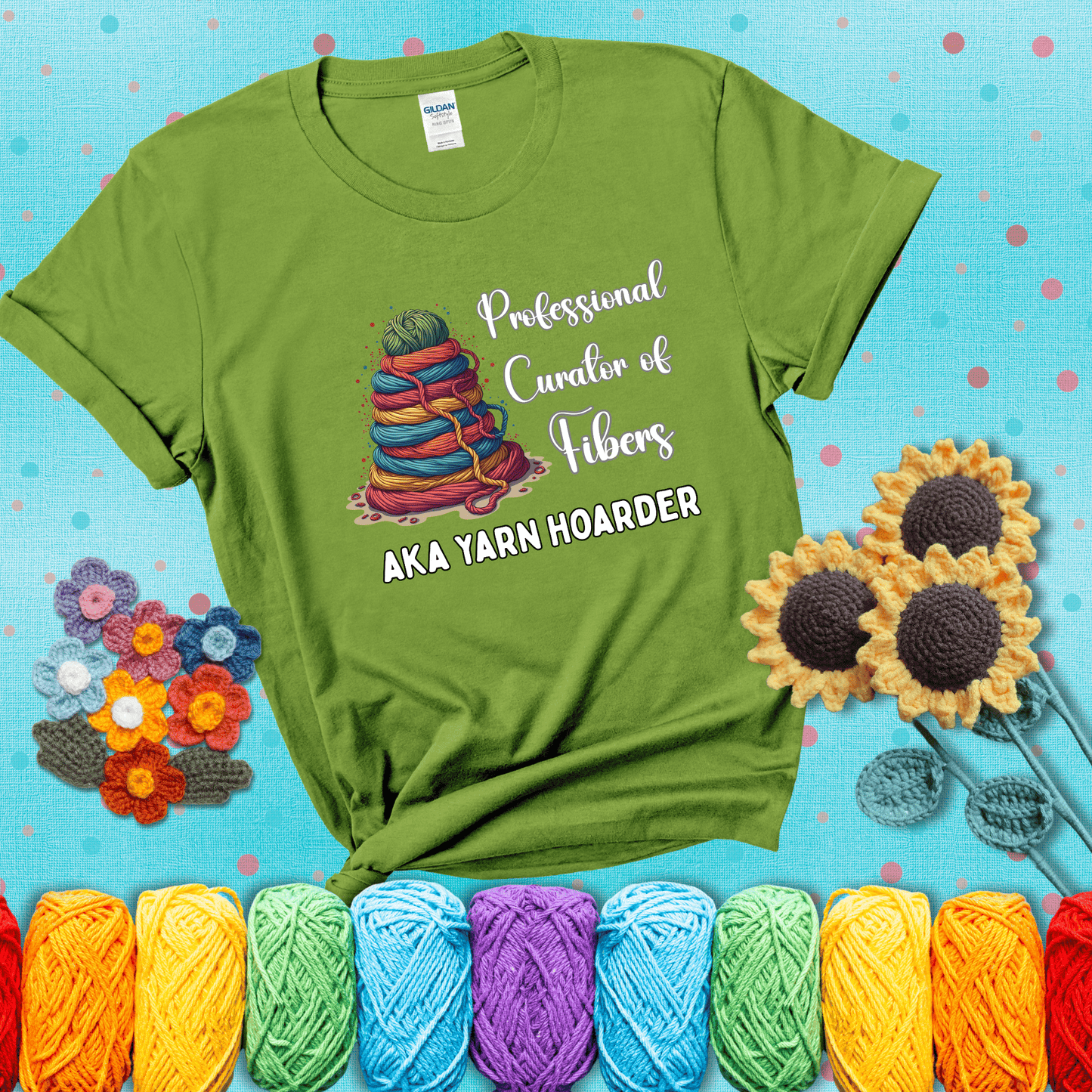Pyramid of rainbow yarn topped with green ball; text reads “Professional Curator of Fibers AKA Yarn Hoarder,” a playful shirt for serious stashers showing a bright green tee with a teal sunflower background