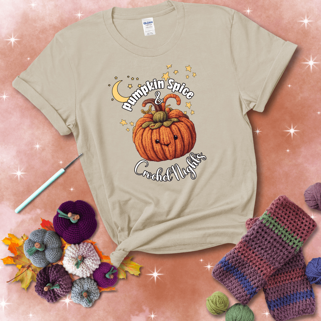 Smiling pumpkin crocheted with yarn texture, surrounded by stars and a crescent moon. Text reads “Pumpkin Spice & Crochet Nights” showing a beige tee with a festive Fall background