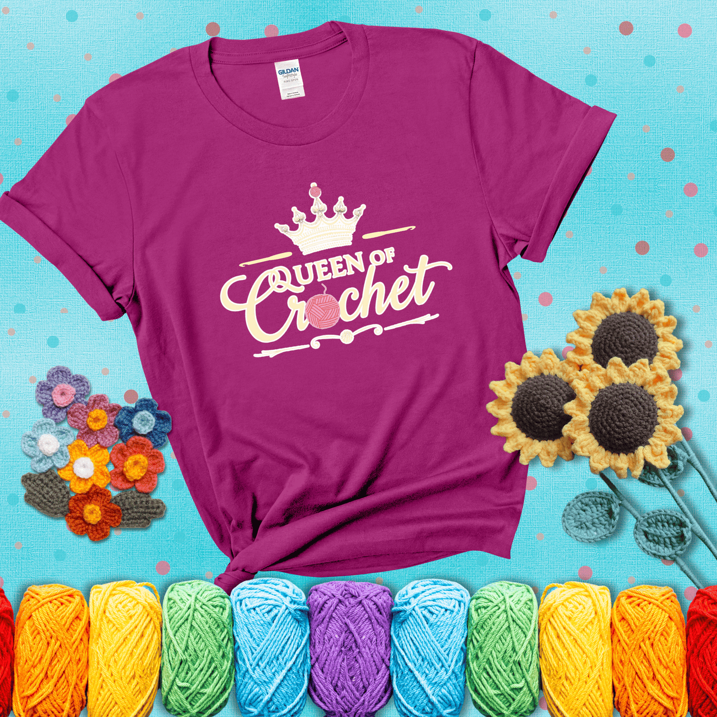 Crown-topped design reads “Queen of Crochet” with elegant script and two pink yarn balls, one forming the letter “o” and another atop the crown showing a magenta tee with a teal sunflower background