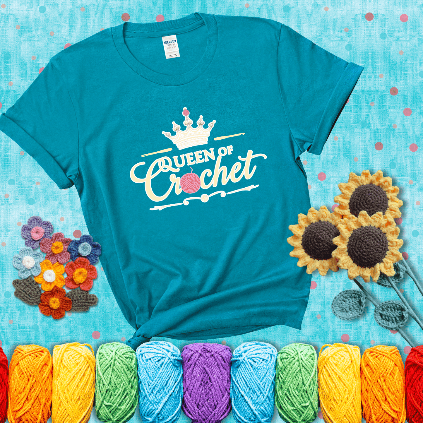 Crown-topped design reads “Queen of Crochet” with elegant script and two pink yarn balls, one forming the letter “o” and another atop the crown showing a blue-green tee with a teal sunflower background