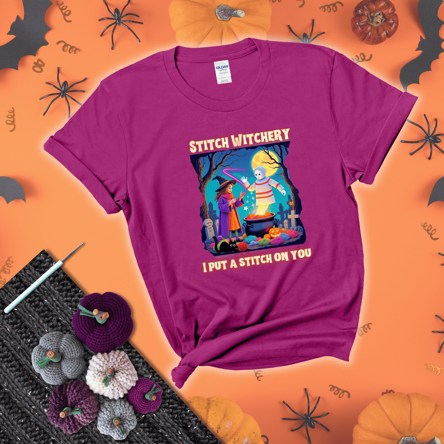 A Halloween scene with a young witch casting a yarn spell from a cauldron onto a floating crochet-ghost figure, under the phrase “I Put a Stitch on You” showing a magenta tee with a festive Halloween background