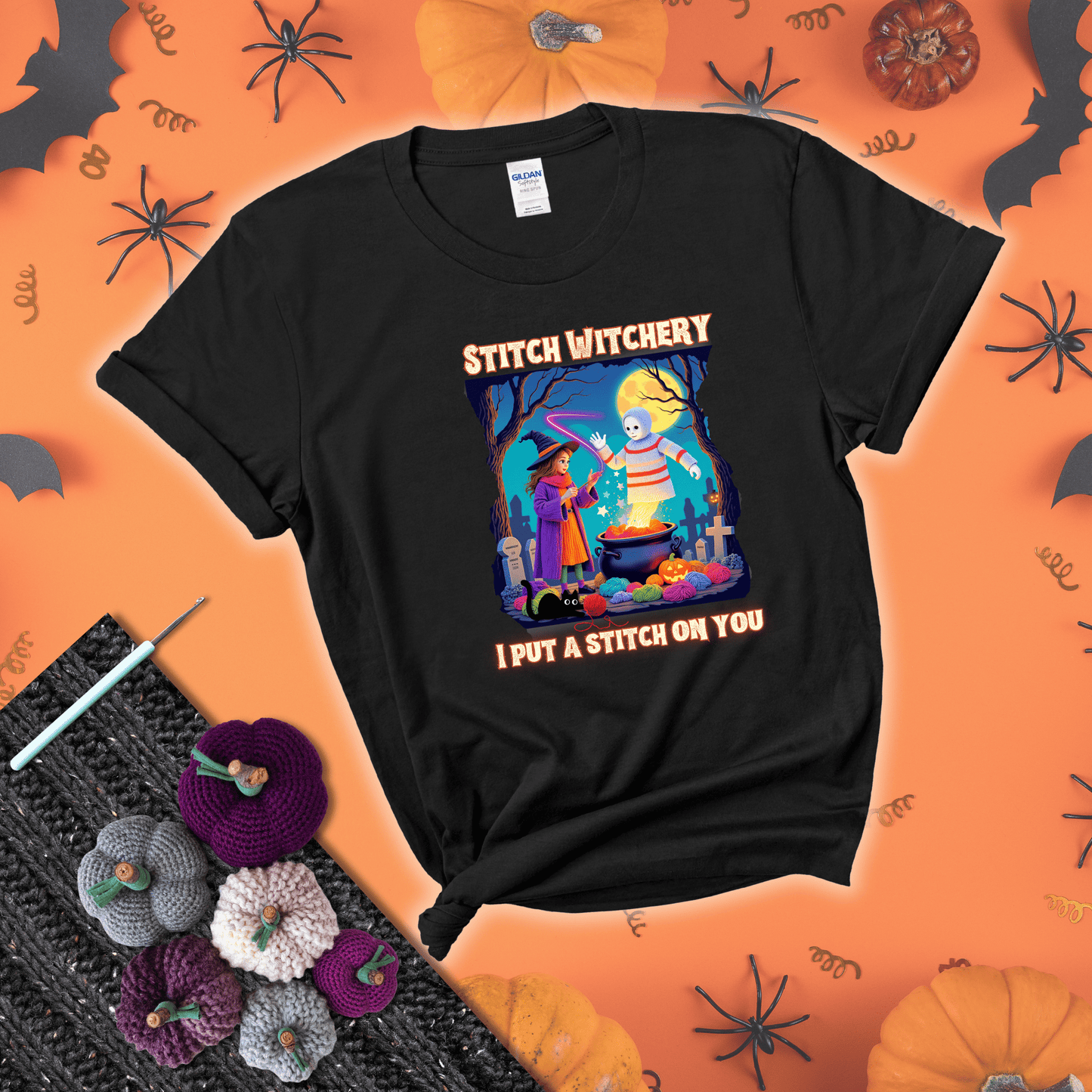 A Halloween scene with a young witch casting a yarn spell from a cauldron onto a floating crochet-ghost figure, under the phrase “I Put a Stitch on You” showing a black tee with a festive Halloween background