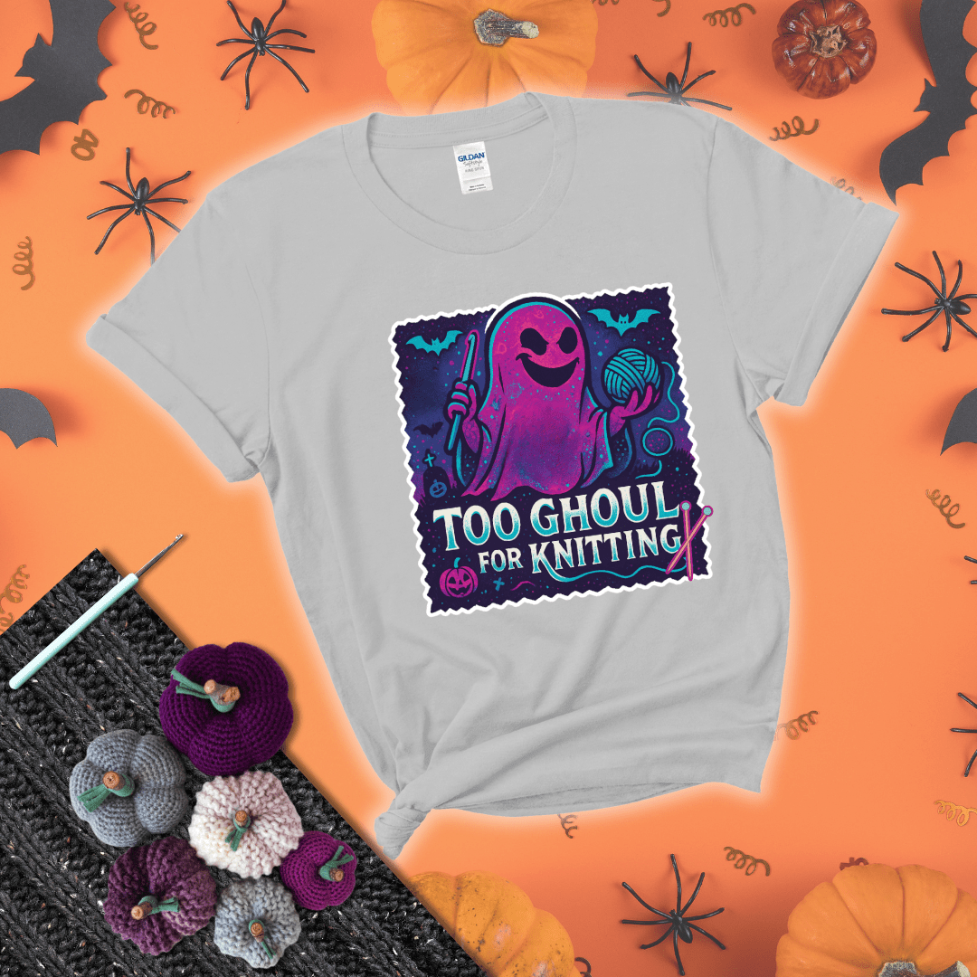 A spooky ghost holds a yarn ball and crochet hook in a vibrant Halloween palette with bats, tombstones, and pumpkins wearing a light grey tee with a festive halloween background