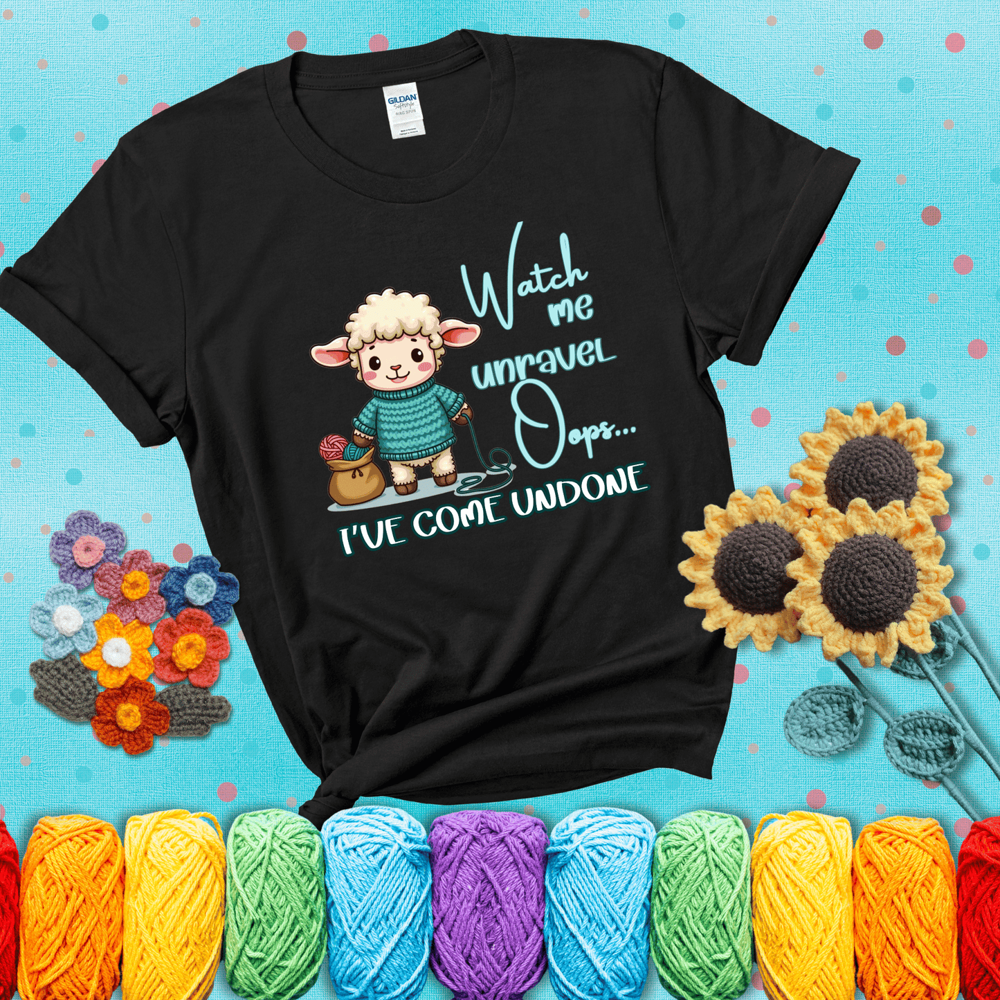 Cute sheep holding yarn looks startled with the phrase “Watch me unravel… Oops, I’ve come undone.” Perfect mix of whimsy and yarn life chaos, showing a black tee with a teal sunflower background