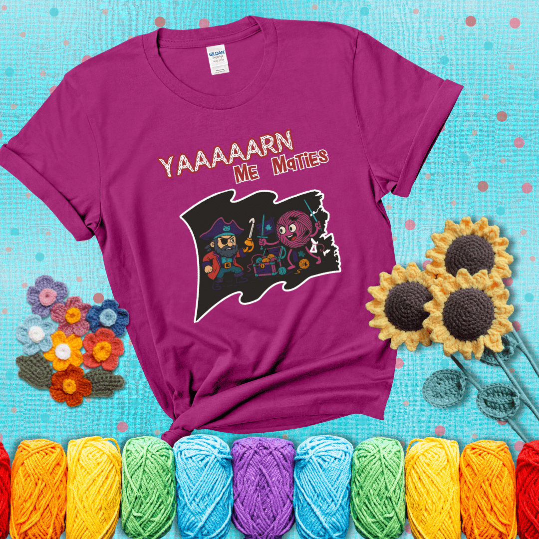 A pirate with a crochet hook for a hand duels a fierce yarn ball wielding knitting needles, standing in front of a treasure chest filled with yarn showing a magenta tee with a teal sunflower background