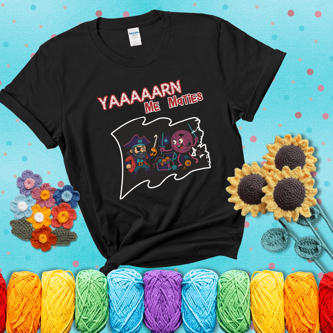 A pirate with a crochet hook for a hand duels a fierce yarn ball wielding knitting needles, standing in front of a treasure chest filled with yarn showing a black tee with a teal sunflower background
