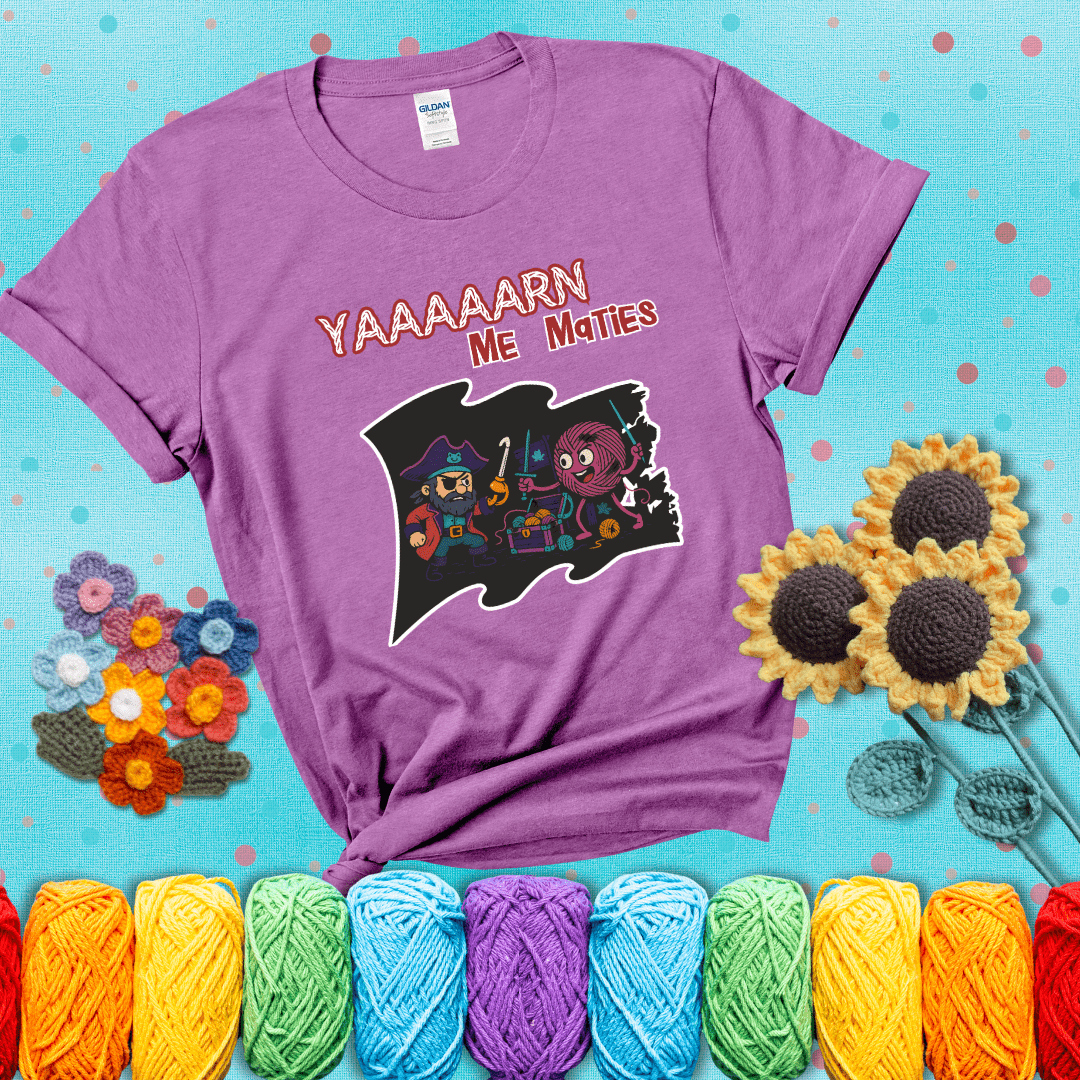 A pirate with a crochet hook for a hand duels a fierce yarn ball wielding knitting needles, standing in front of a treasure chest filled with yarn showing a light purple tee with a teal sunflower background