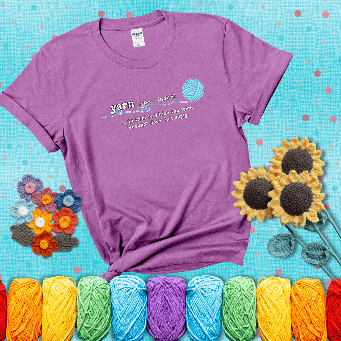 A definition-style graphic showing the word "yarn" as a noun, with the definition “An item to which the term ‘enough’ does not apply,” and a ball of blue yarn with a loose strand showing a light purple tee with a teal sunflower background