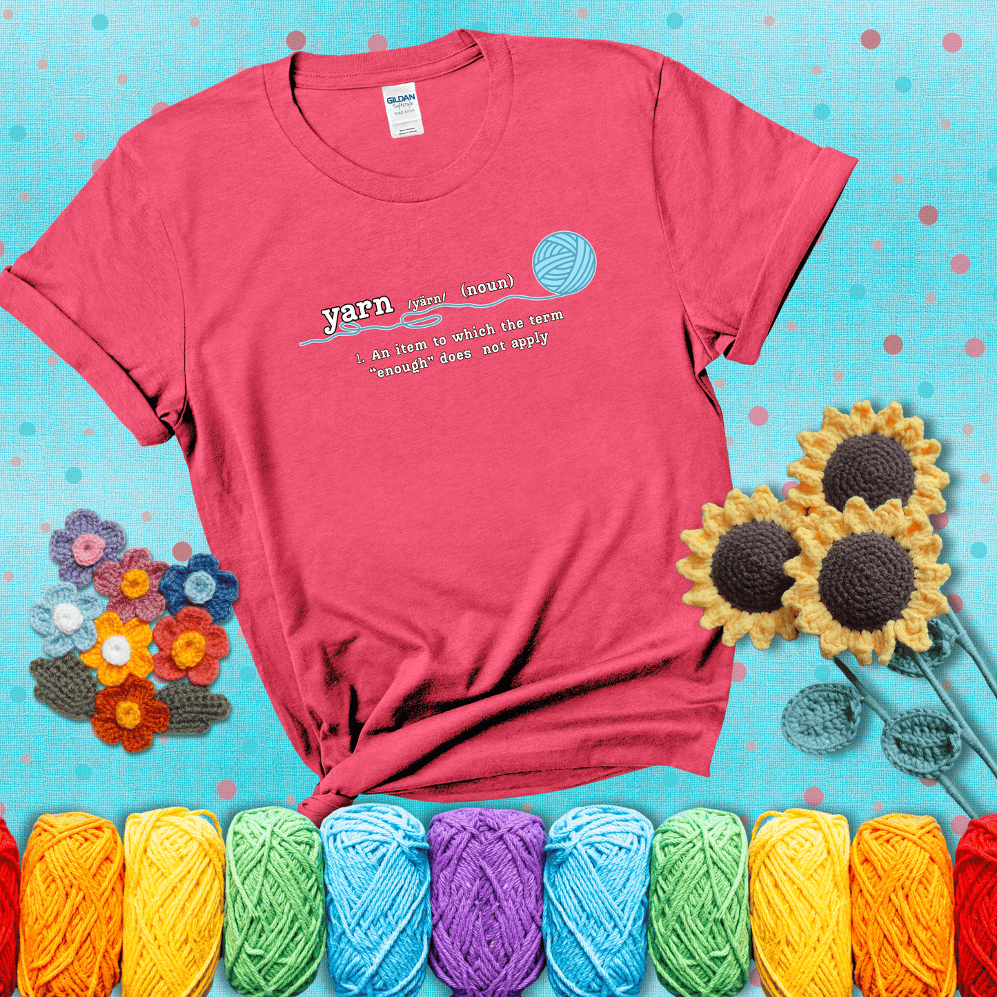 A definition-style graphic showing the word "yarn" as a noun, with the definition “An item to which the term ‘enough’ does not apply,” and a ball of blue yarn with a loose strand showing a light red tee with a teal sunflower background