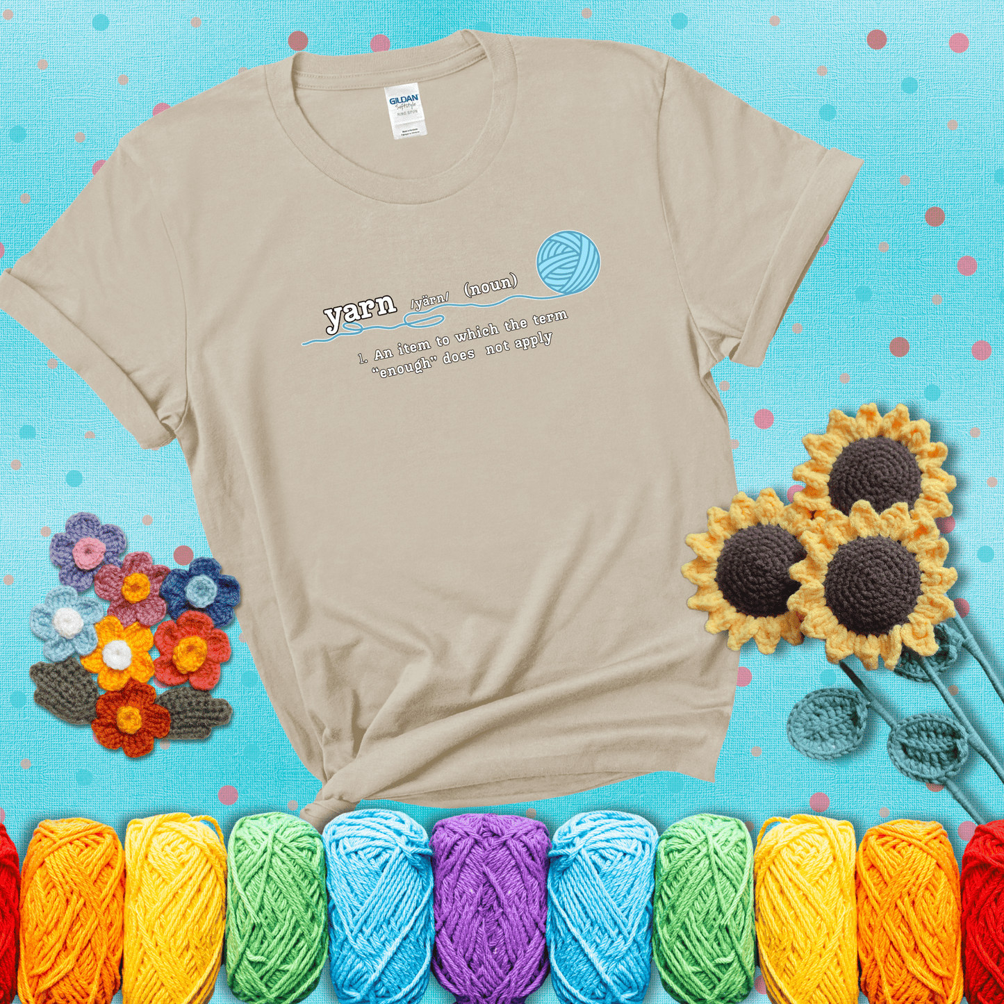 A definition-style graphic showing the word "yarn" as a noun, with the definition “An item to which the term ‘enough’ does not apply,” and a ball of blue yarn with a loose strand showing a beige tee with a teal sunflower background