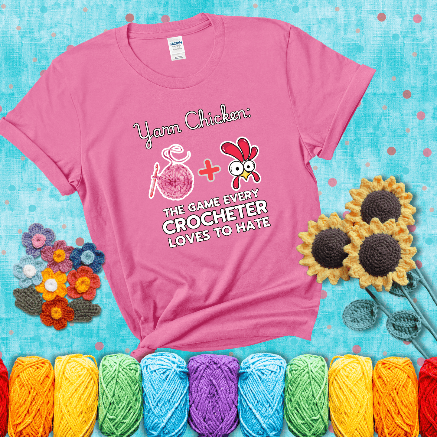 Cartoon chicken inside a yarn ball with crochet circle background. Text reads: “Yarn Chicken: The Game Every Crocheter Loves to Lose.” A fun and relatable tee for fiber artists who like to live on the edge, showing a pink tee with a teal sunflower background