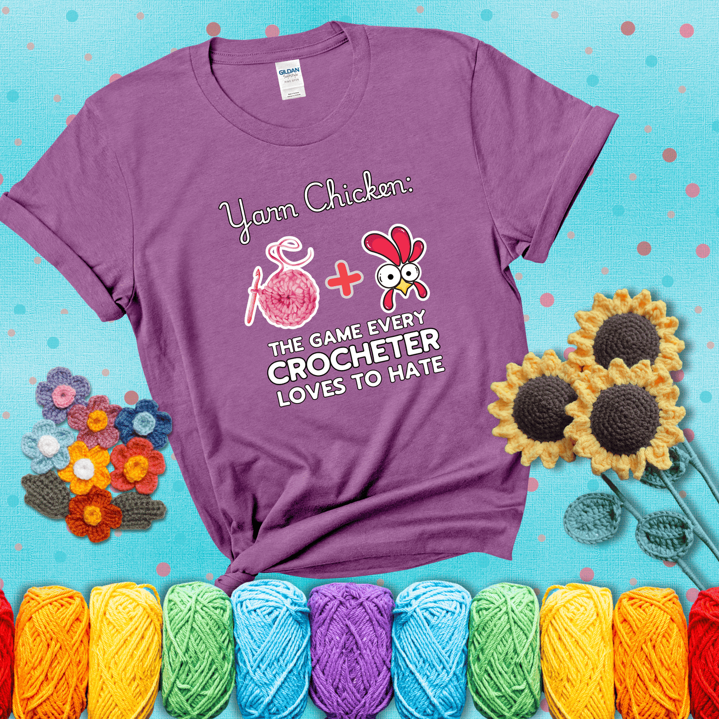 Cartoon chicken inside a yarn ball with crochet circle background. Text reads: “Yarn Chicken: The Game Every Crocheter Loves to Lose.” A fun and relatable tee for fiber artists who like to live on the edge, showing a light purple tee with a teal sunflower background