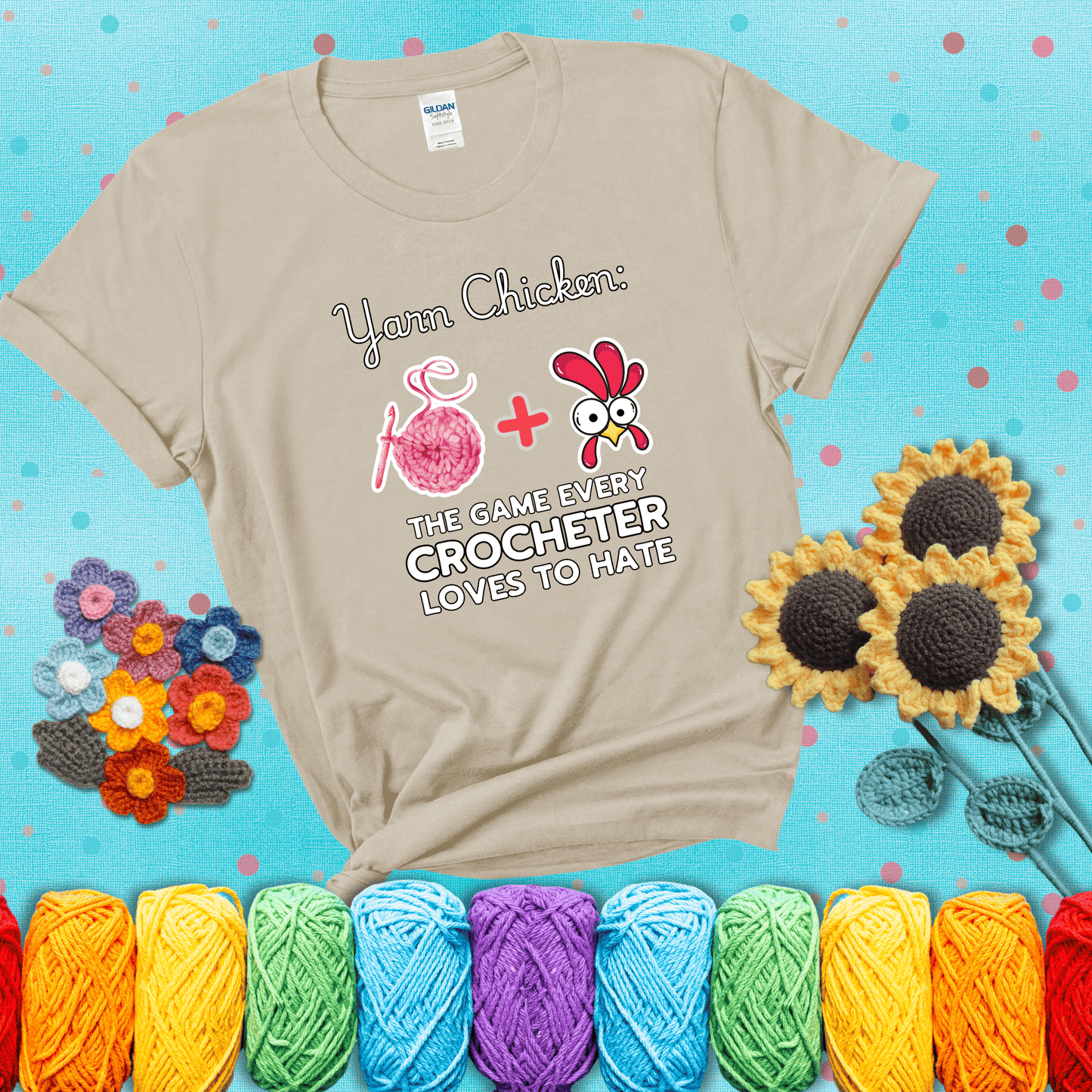 Cartoon chicken inside a yarn ball with crochet circle background. Text reads: “Yarn Chicken: The Game Every Crocheter Loves to Lose.” A fun and relatable tee for fiber artists who like to live on the edge, showing a beige tee with a teal sunflower background