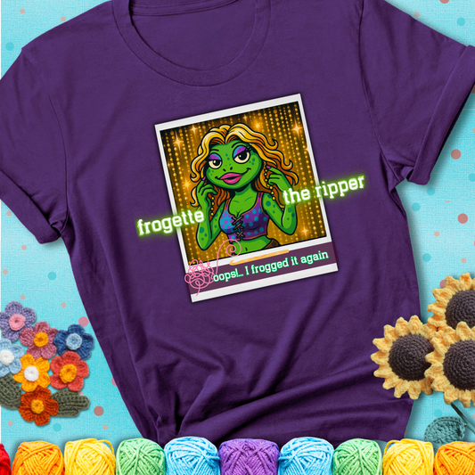 Retro-styled illustration of a glamorous green frog in a sparkly outfit, labeled "Frogette the Ripper" with the phrase “Oops! I frogged it again” below, referencing both crochet and pop culture showing a purple tee with a teal sunflower background