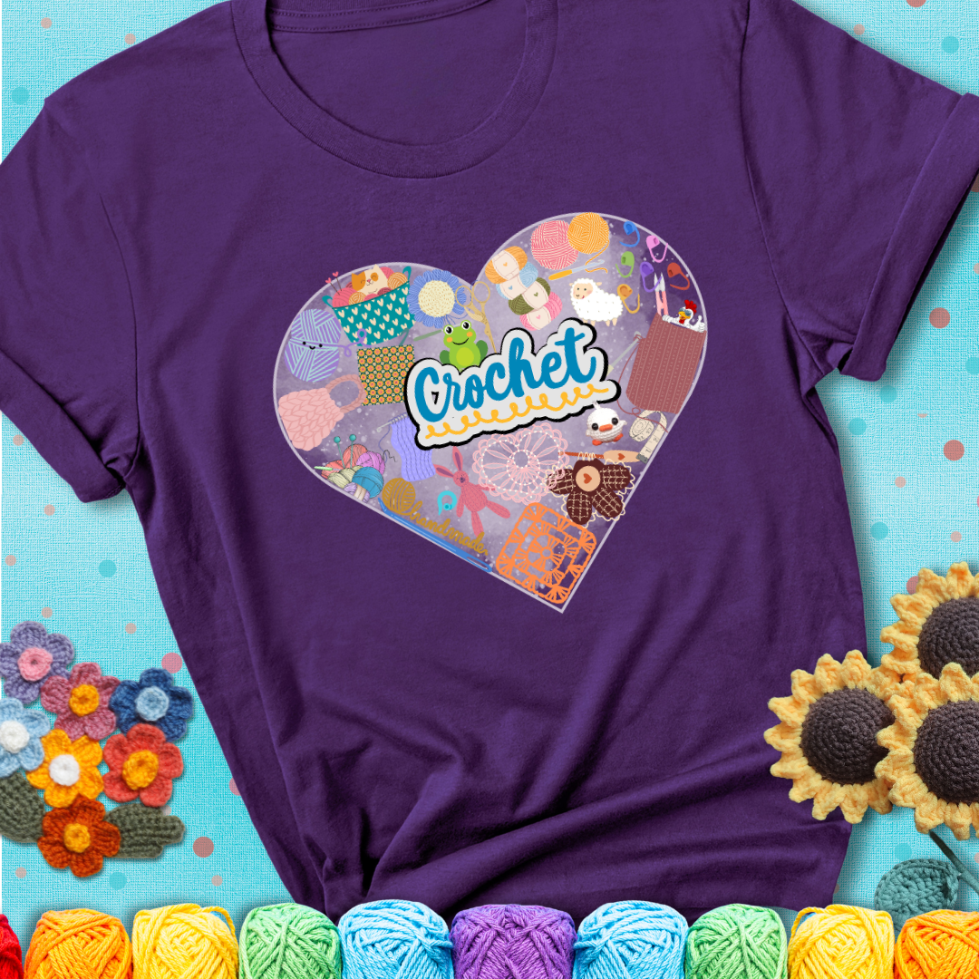 A heart filled with colorful crochet essentials including yarn, hooks, scissors, notions, and handmade items, with the word "Crochet" prominently in the center of a purple t-shirt.
