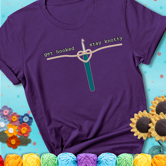 Hooked on yarn? Same Design reads 'Get Hooked, Stay Knotty' , perfect crochet gift for yarn lovers, showing a purple tee with a teal sunflower background