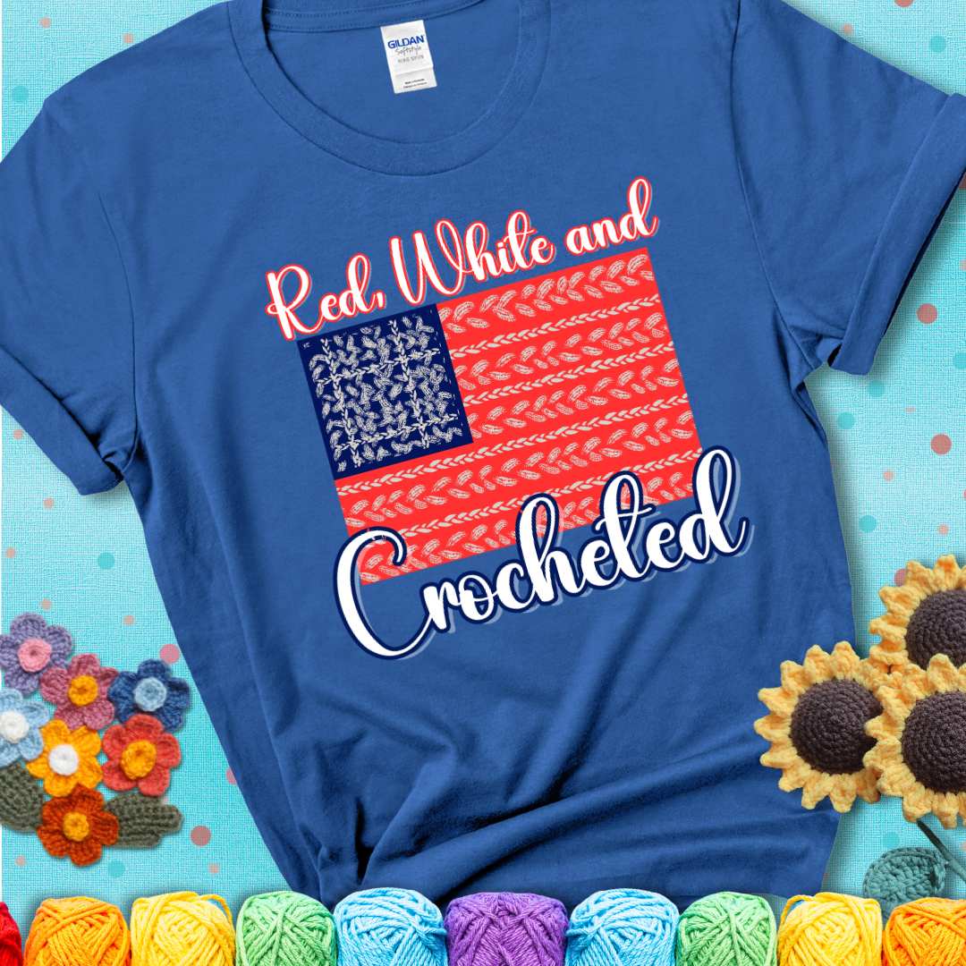 Blue t-shirt showing a patriotic crochet-themed American flag design with red and white yarn stitches forming the stripes and blue and white stitches as stars.