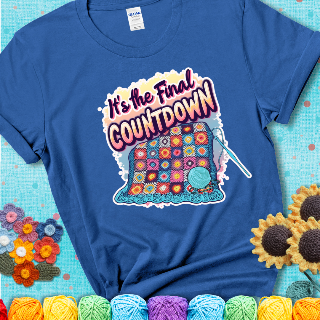 Royal Blue t-shirt with a colorful crochet blanket in progress, blue yarn ball, crochet hook, and the phrase “It’s The Final Countdown.”
