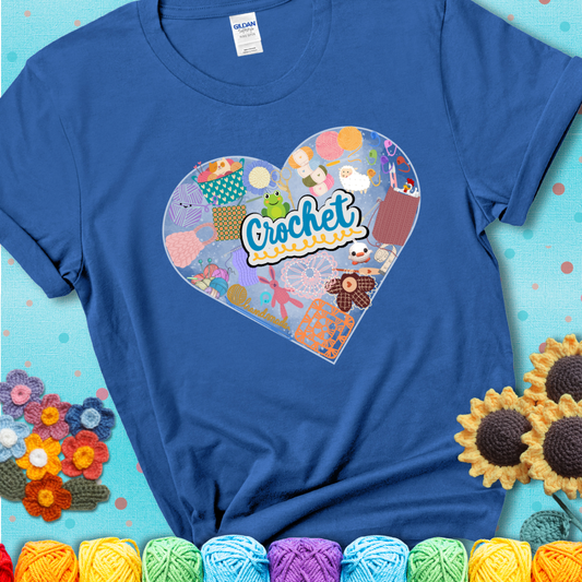 A heart filled with colorful crochet essentials including yarn, hooks, scissors, notions, and handmade items, with the word "Crochet" prominently in the center of a blue t-shirt.