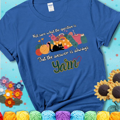 Royal blue t-shirt with a black cat beside a basket of colorful yarn and the phrase, “Not Sure What The Question Was, But The Answer Is Yarn.”