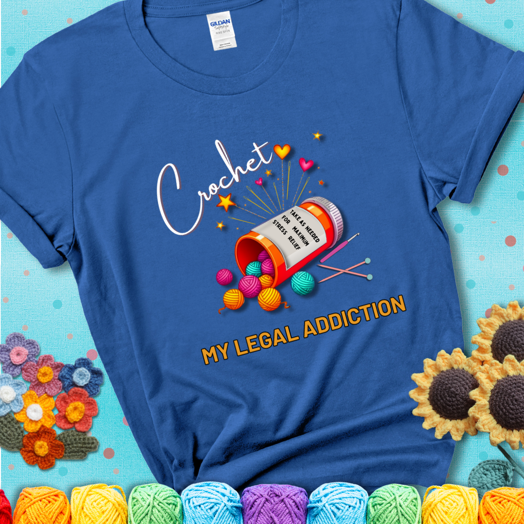 Royal blue t-shirt with a prescription bottle spilling colorful yarn balls, small crochet details, and the phrase “Crochet: My Legal Addiction.”