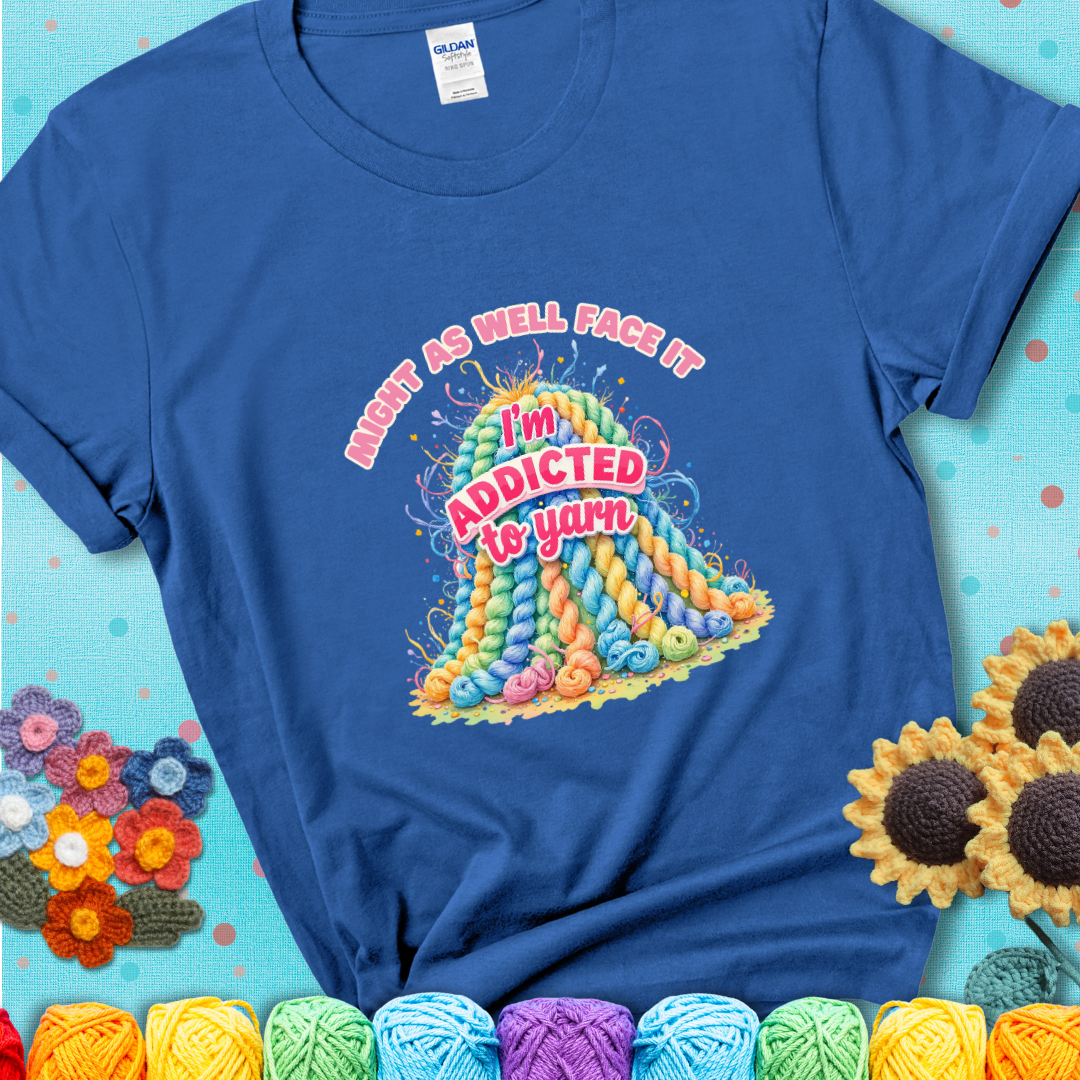 Royal Blue t-shirt with a colorful mountain of pastel yarn hanks and the phrase “Might As Well Face It, I’m Addicted To Yarn” in pink and red lettering.