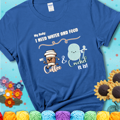 Design reads “My body: I need water and food. Me: Coffee & Crochet it is,” with a smiling coffee cup and yarn ball characters on a blue t-shirt.