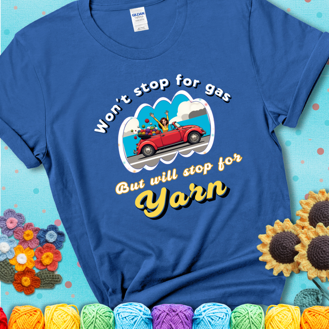 Royal blue t-shirt with a woman driving a red convertible filled with yarn and the phrase “Won't Stop For Gas But Will Stop For Yarn.”