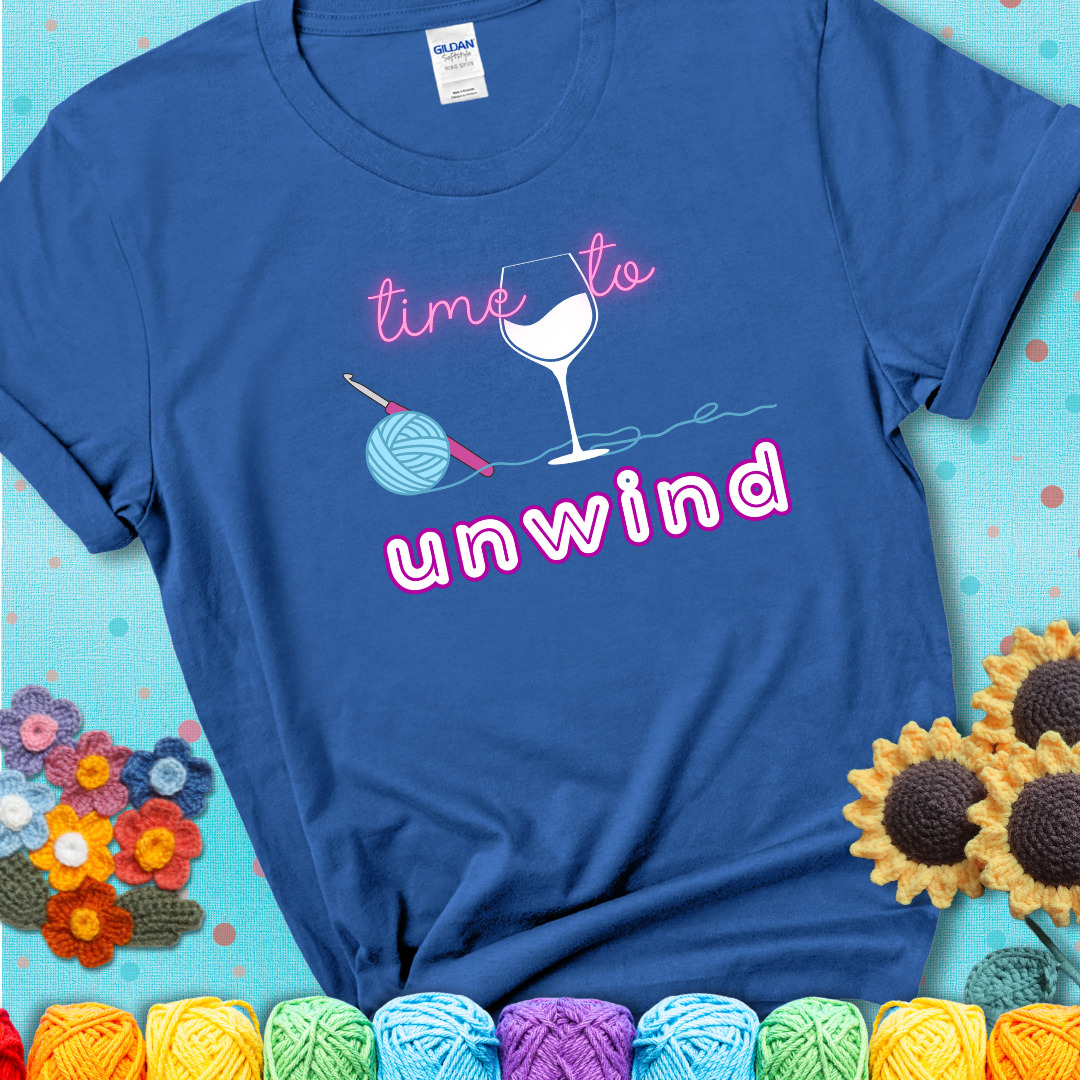 Wine down with your yarn out Design reads 'Time To Unwind' , perfect crochet gift for yarn lovers showing a blue tee with a teal sunflower background