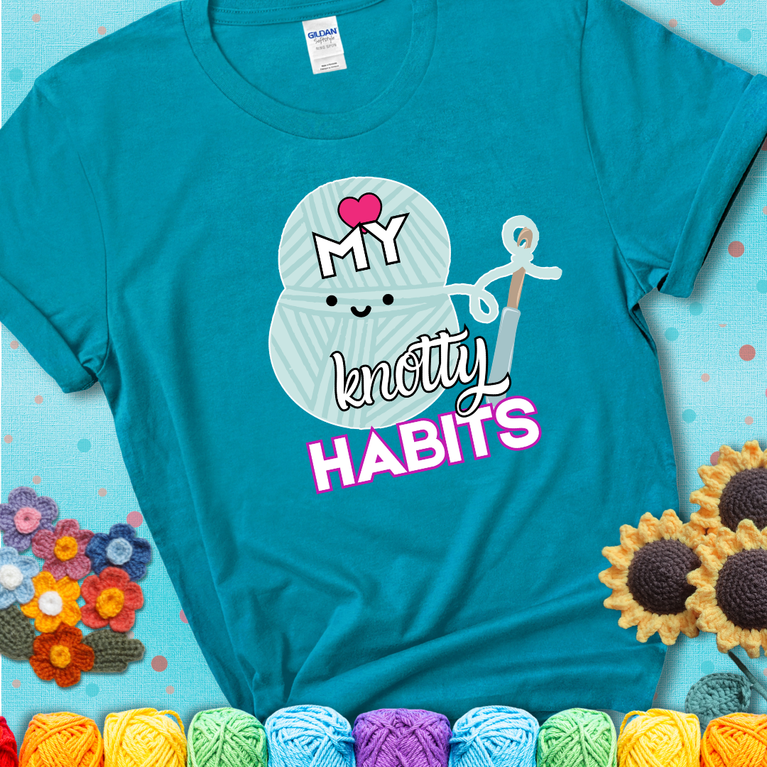Smiling yarn ball and hook with text “Love My Knotty Habits” - cute crochet shirt with playful design for makers, showing a blue-green teal tee with a teal sunflower background