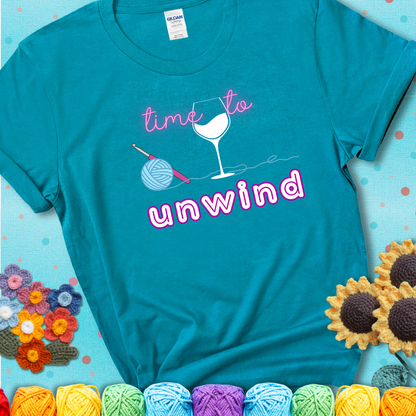 Wine down with your yarn out Design reads 'Time To Unwind' , perfect crochet gift for yarn lovers showing a blue-green teal tee with an aqua sunflower background