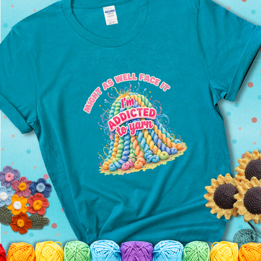 Tropical Blue t-shirt with a colorful mountain of pastel yarn hanks and the phrase “Might As Well Face It, I’m Addicted To Yarn” in pink and red lettering.