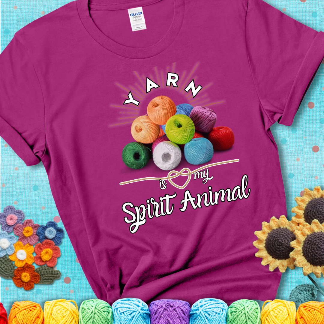 Stack of colorful yarn balls with radiant glow. Text reads: “Yarn Is My Spirit Animal.” A calming and colorful tee for fiber lovers who find zen in stitching, showing a magenta tee with a teal sunflower background