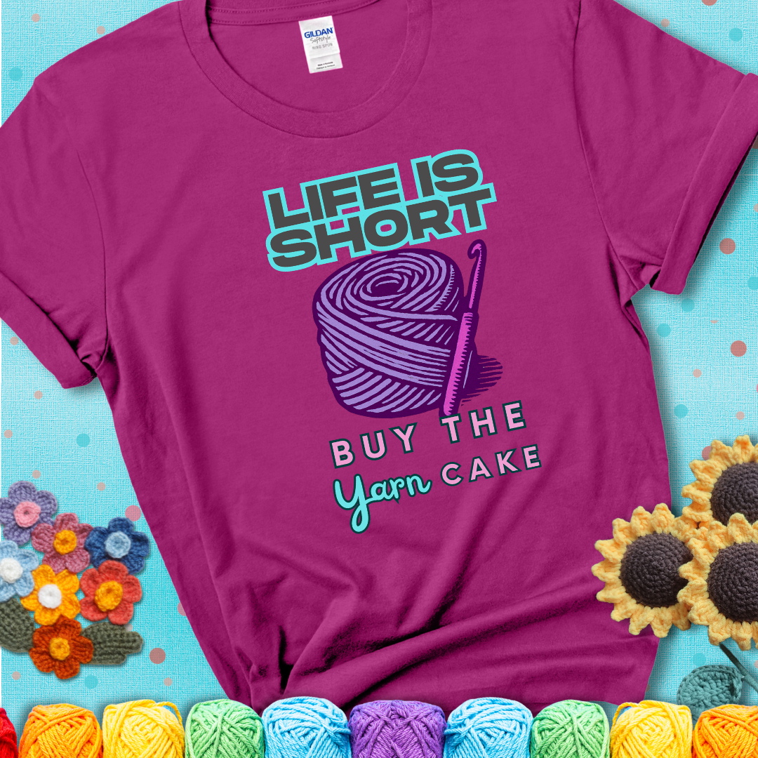 No regrets, just yarn. Design reads 'Life Is Short. Buy The Yarn (Cake)' , perfect crochet gift for yarn lovers, showing a magenta tee with a teal sunflower background