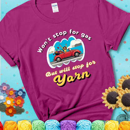 Antique Heliconia t-shirt with a woman driving a red convertible filled with yarn and the phrase “Won't Stop For Gas But Will Stop For Yarn.”