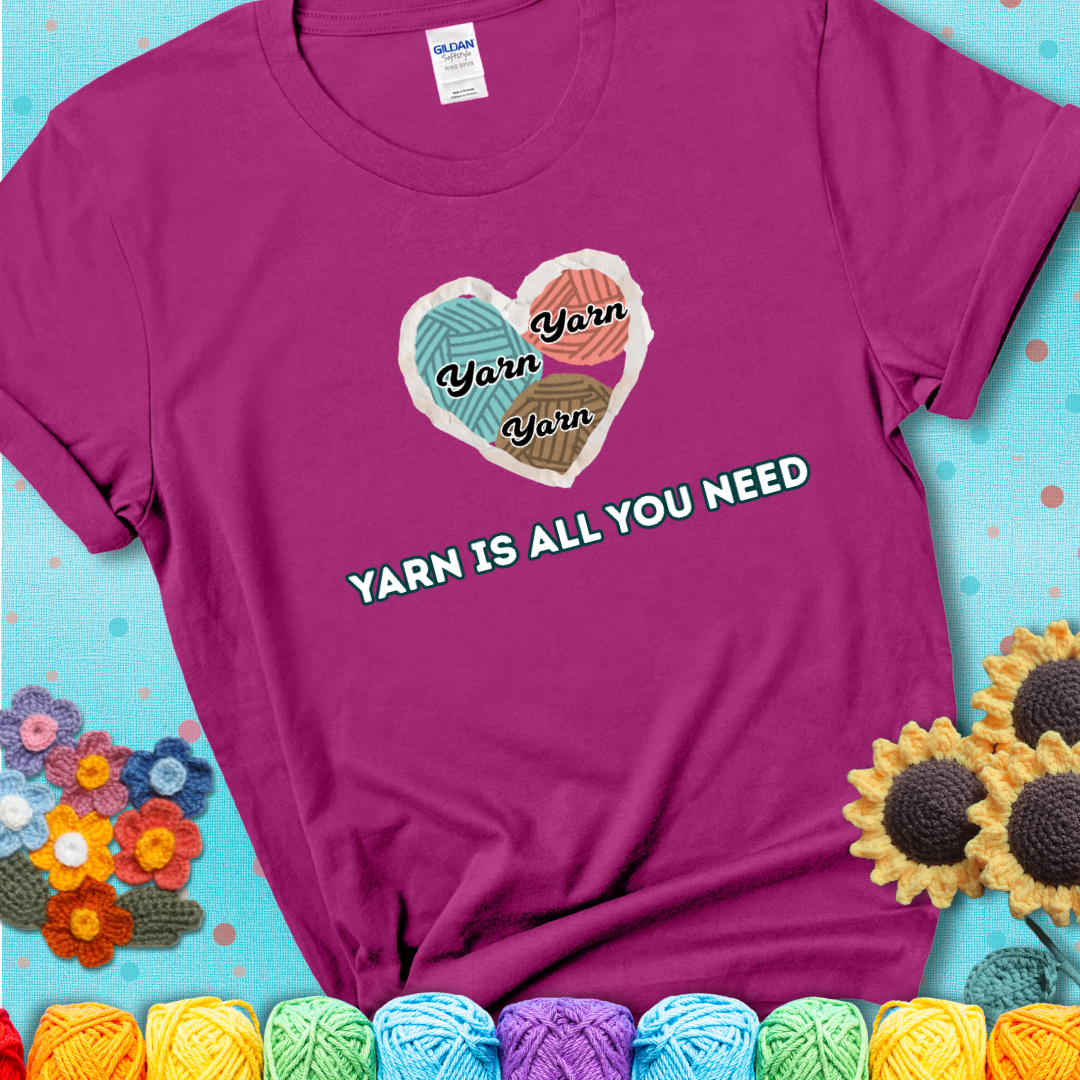 Antique Heliconia t-shirt with a colorful heart made of yarn textures and the phrase “Yarn Is All You Need” in retro lettering.