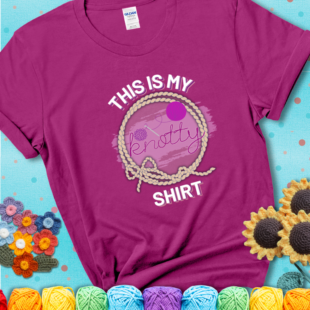 Antique Heliconia t-shirt with the phrase “This is My Knotty Shirt” inside a rope circle, featuring a yarn ball and crochet hook forming the word “knotty.”